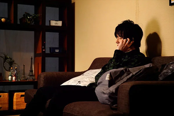 ソファに座り、電話をしながら考え込む彼の横顔。部屋の静けさが、胸の奥をざわつかせる。